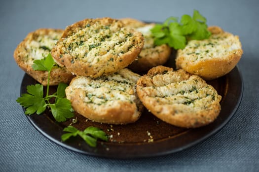 Plate of grilled or toasted crispy bread seasoned with fresh herbs to serve as an accompaniment to a meal