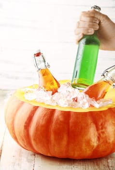 Hand Taking Cold Bottled Alcoholic Drink from Pumpkin Ice Bucket