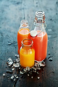 Fresh Colored Juice Glass Bottles on Vintage Wooden Table
