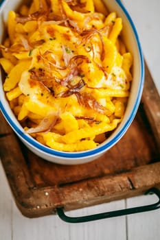 German or Bavarian cuisine with spaetzle, or traditional egg noddles made by pouring batter through a colander into boiling water, in a casserole dish with a spicy sauce