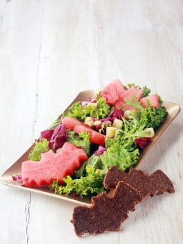 Halloween Salad with Bat Shaped Garnishes on Wooden Background with Copyspace