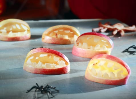 Scary Halloween decorations for trick-or-treat favors or party table decorations with gaping open apple mouths with teeth and crawling spiders in a fun homemade concept