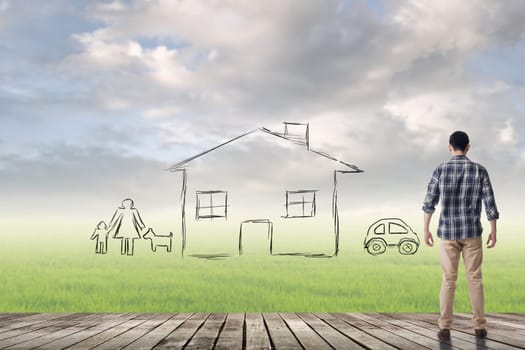 Asian man against the drawing house and family over grassland.