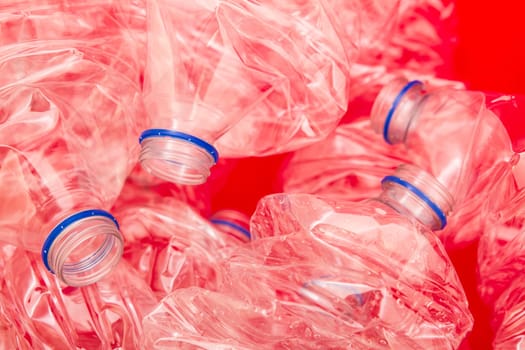 Squeezed bottles of mineral water with a red background.