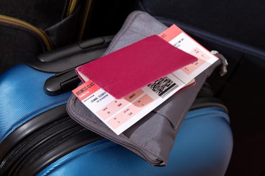 Airline ticket, passport and luggage, ready to travel.