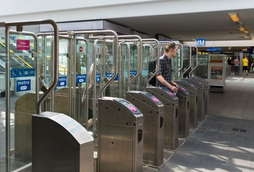 man passing an automatic gate at an amsterdam railway station