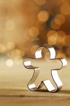 Snowman cookie cutter with a sparkling sepia bokeh of sparkling party lights celebrating Christmas with copyspace for your greeting