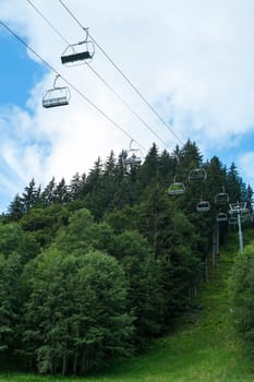 Low angle shot of alpine air lift with trees in the background