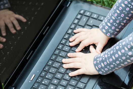 Child's hands on the laptop's keyboard