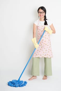 Full length Asian Chinese girl housekeeping, mopping floor on plain background.