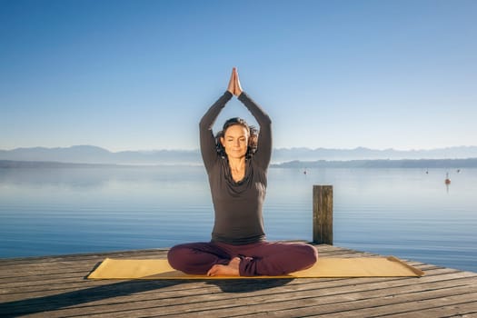 An image of a pretty woman doing yoga at the lake