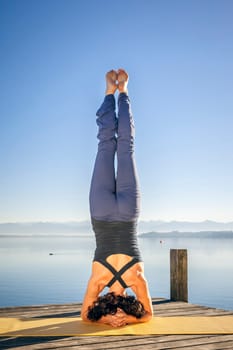 An image of a pretty woman doing yoga at the lake