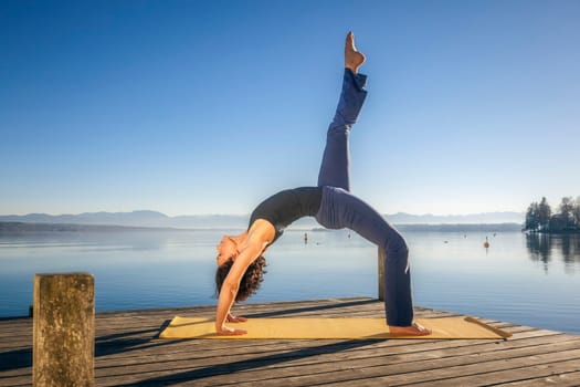 An image of a pretty woman doing yoga at the lake