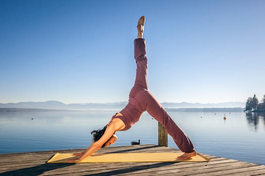 An image of a pretty woman doing yoga at the lake