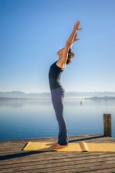 An image of a pretty woman doing yoga at the lake