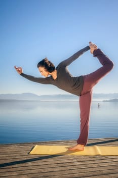 An image of a pretty woman doing yoga at the lake