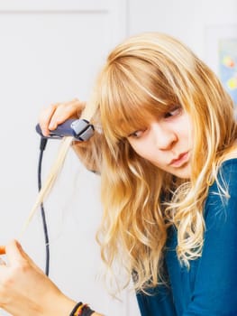 An image of a beautiful teenage girl smooting her hair