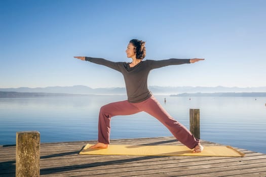 An image of a pretty woman doing yoga at the lake