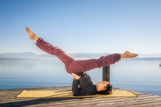 An image of a pretty woman doing yoga at the lake