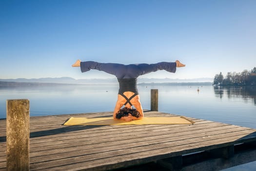An image of a pretty woman doing yoga at the lake