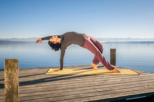 An image of a pretty woman doing yoga at the lake