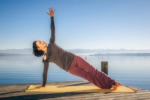 An image of a pretty woman doing yoga at the lake