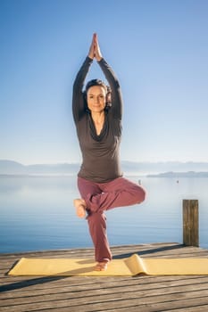 An image of a pretty woman doing yoga at the lake