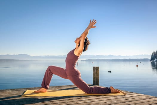 An image of a pretty woman doing yoga at the lake
