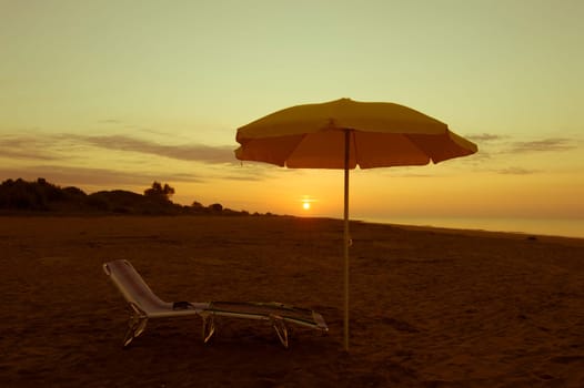 umbrella on the beach, with sun and sea on background