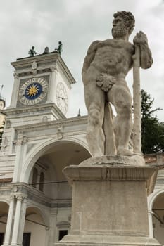 Caco statue in the background with the clock tower of Udine, Italy
