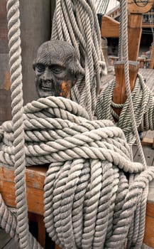 Ropes around a head shaped wooden cleat on an old vessel