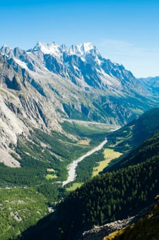 Val Veny valley in Val d'Aosta, in Italy, with Dora di Val Veny river and forests on hillsides.