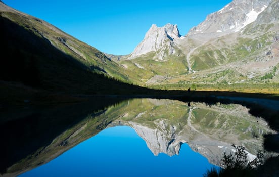 Limestone Pyramids reflected on Combal Lake waters in Val Veny, Italy