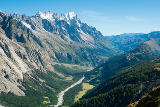 Val Veny valley in Val d'Aosta, in Italy, with Dora di Val Veny river and forests on hillsides.