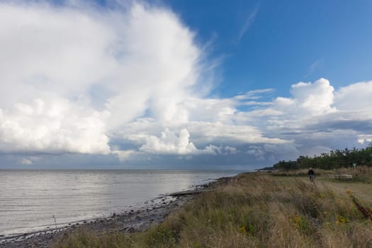 Grass-covered coastal strip with impressive cloud formation