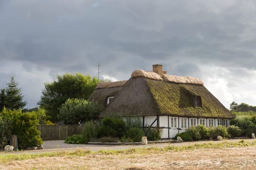Holiday house on a small street with dark clouds in the background