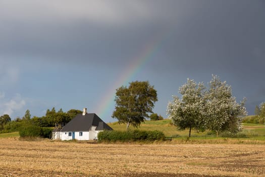 Small stone hut with a rainbow in the background