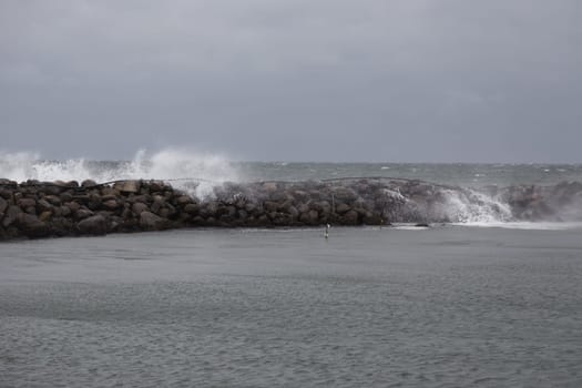 Waves hit the breakwater in the port of Bagenkop,Langeland