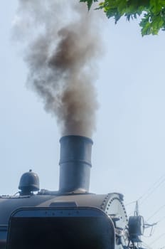 Steam locomotive under full steam at exit from a station.