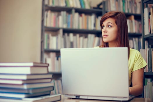 Beautiful student using laptop in library