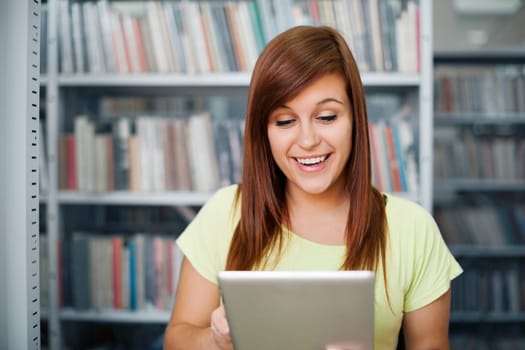 Happy student using digital tablet in library
