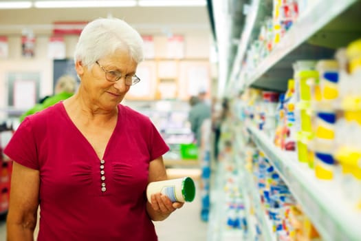 Senior woman checking label on jar