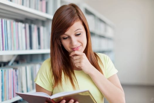 University student reading book in library