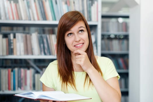Young woman daydreaming in library