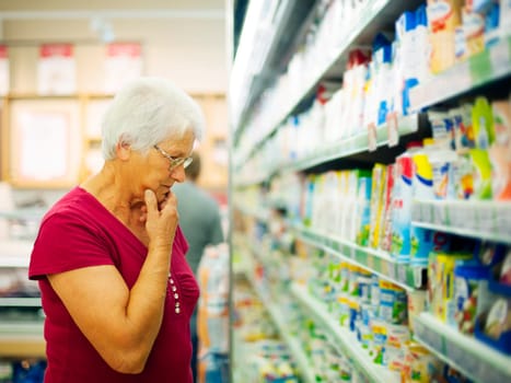 Senior woman choosing a dairy products at supermarket