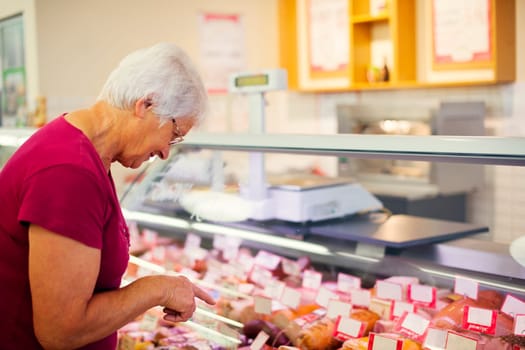 Senior woman in butchers shop