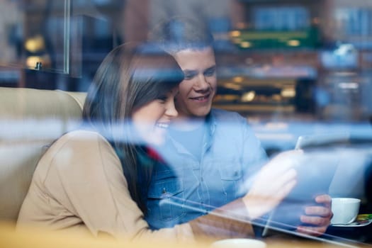 Young couple using tablet in coffee shop