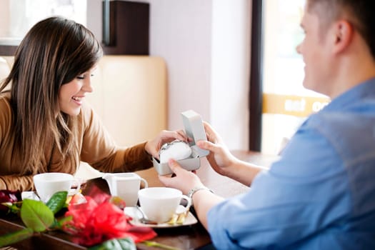 Young man giving a watch his girlfriend on Valentine's Day