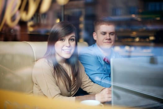 Young couple using laptop in coffee shop