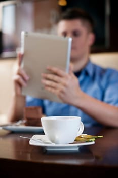 Young man using tablet in coffee shop